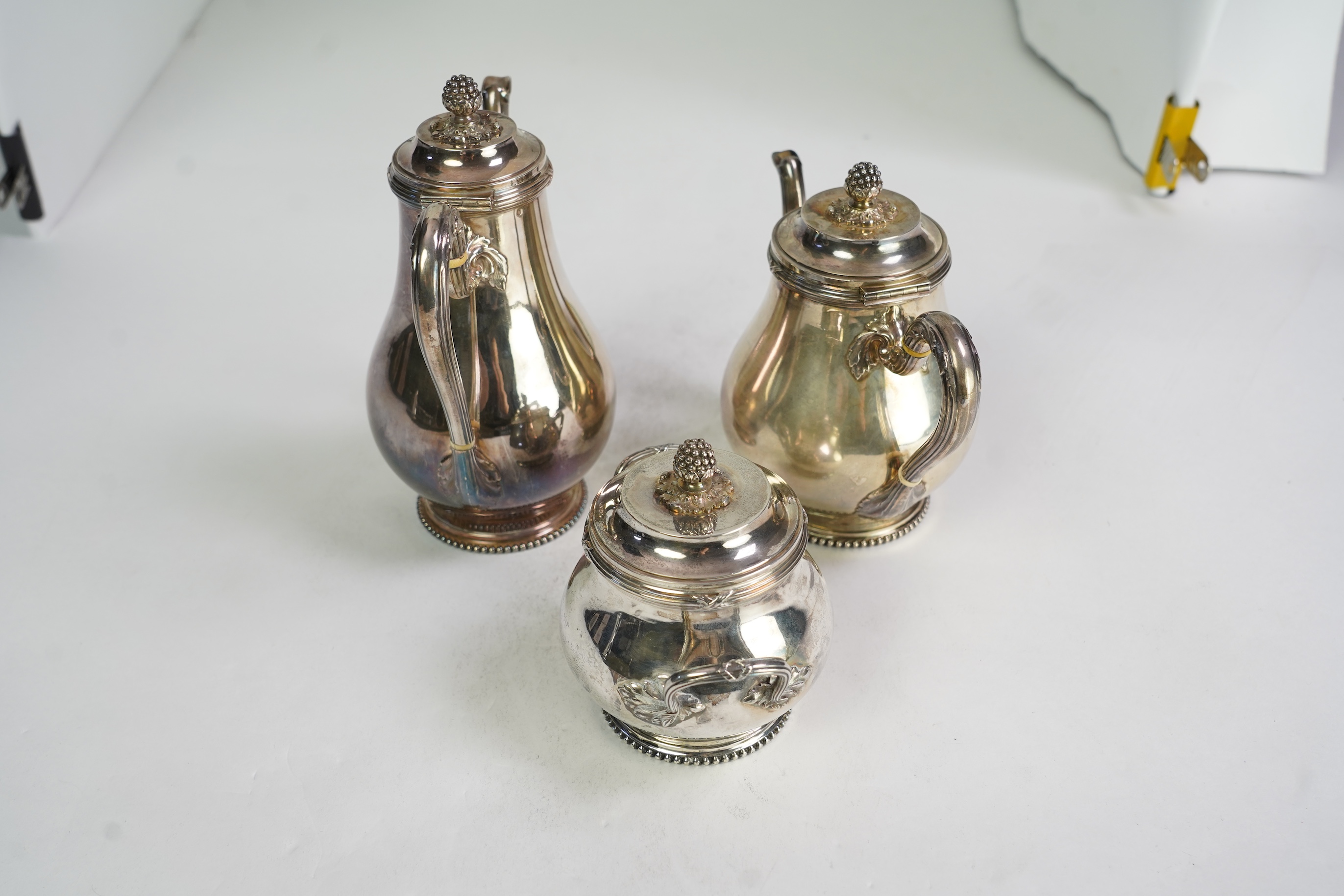 An early 20th century French silver three piece tea and coffee set, comprising a teapot, coffee pot and two handled sugar bowl, by Henin & Cie